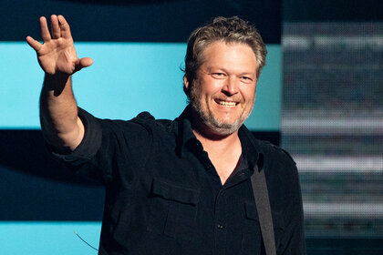 Blake Shelton smiling and waving his right hand