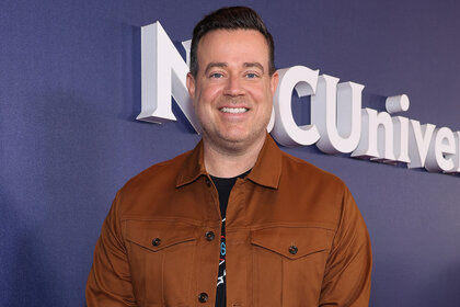 Carson Daly smiling on an NBC red carpet