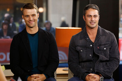 Jesse Spencer and Taylor Kinney sitting together, smiling