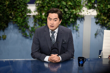 Bowen Yang playing a news reporter in an SNL skit