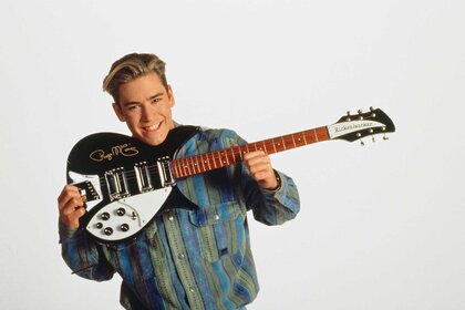 Zack Morris holding a guitar for a promotional photo for Saved By The Bell.