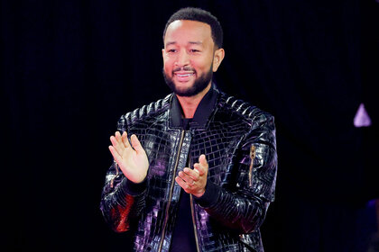 John Legend stands and applauds a performance during the voice episode 2412