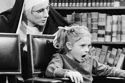 A nun (Mary Gross) speaks to Drew Barrymore on Saturday Night Live on November 20, 1982.