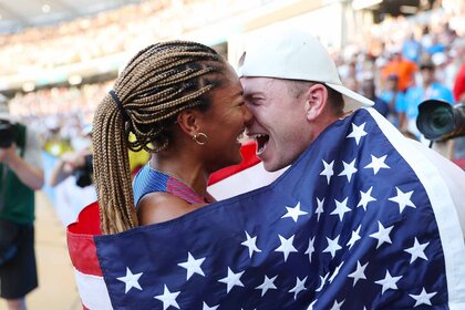 Tara Davis-Woodhall and Hunter Woodhall share an intimate moment wrapped in an American flag.