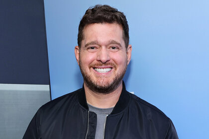 Michael Bublé smiles in front of a blue background