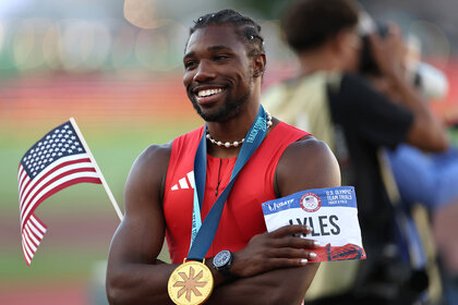 Noah Lyles poses with his medal and flag after winning the men's 100 meter final