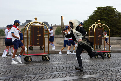 A torcherbearer runs in 2024 Olympics Opening Ceremony