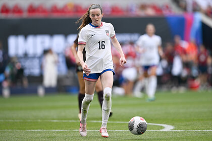 Rose Lavelle dribbles a soccer ball on the field