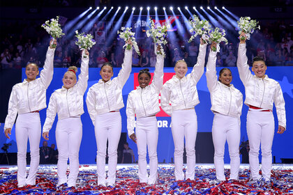 The 2024 Us Olympic Womens Gymnastics Team hold up flowers after the last day of trials