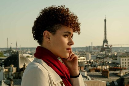 Zee (Nathalie Emmanuel) speaks on a phone in Paris in The Killer (2024).