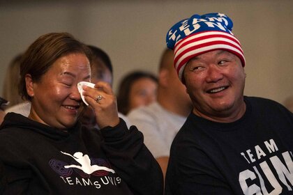 John Lee (R), Sunisa Lee's father, and Yeev Thoj smile.