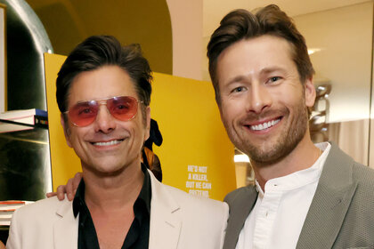 John Stamos and Glen Powell smile together at a screening for Hit Man
