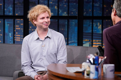 Michael Cera smiles during an interview with Seth Meyers