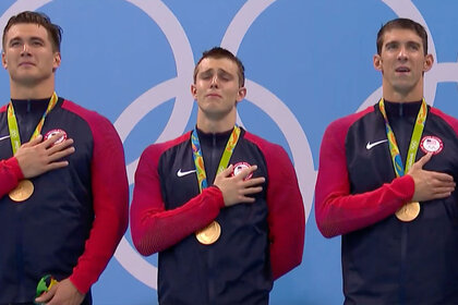 Gold medalists Nathan Adrian, Ryan Held, Michael Phelps sing the national anthem during the medal ceremony for the Final of the Men's 4 x 100m Freestyle Relay on Day 2 of the Rio 2016 Olympic Games