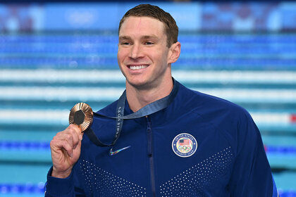 Ryan Murphy poses with his bronze medal on the podium of the men's 100m backstroke swimming event during the Paris 2024 Olympic Games