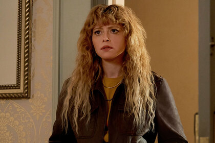 Natasha Lyonne, as Charlie Cale in Poker Face, standing in a doorway.