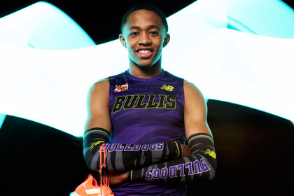 Quincy Wilson posing in front of a backdrop in a uniform.