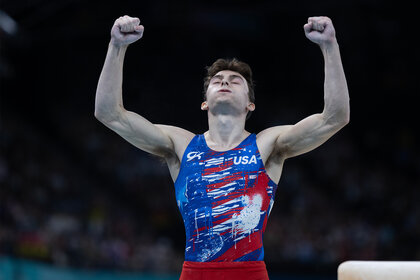 Stephen Nedoroscik holds his arms up celebrating at the 2024 Olympics