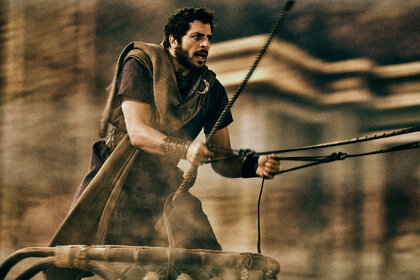 Dimitri Leonidas as Scorpus racing a chariot