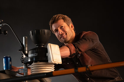 Tyler smiles next to some equipment in Twisters