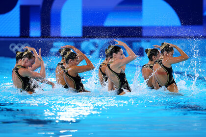 The US Artistic Swimming Team do a dance move in the pool at the 2024 Olympics