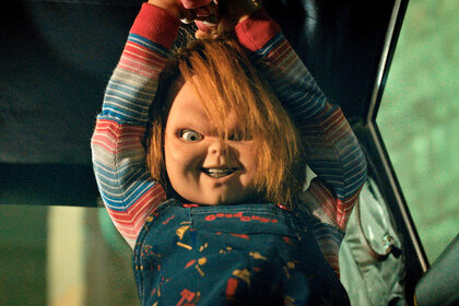 Chucky holds up a knife with an evil smile on his face on Chucky Episode 303