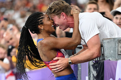 Tara Davis-Woodhall of Team United States celebrates with her husband Hunter Woodhall after winning the gold medal in the Women's Long Jump Finalat the Paris 2024 Olympics