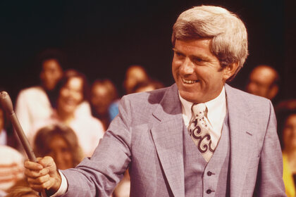 Phil Donahue holds a microphone in the audience on his talk show the phil donahue show in 1977