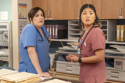 Alex and Serena standing behind a desk during the Pilot Episode of St. Denis Medical.