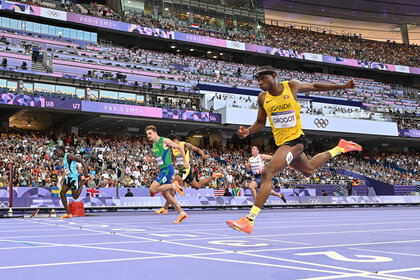 Tarsis Gracious Orogot crosses the finish line in sponge bob squarepants socks at the 2024 Olympics