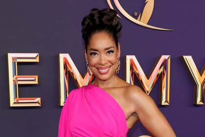 Gina Torres wearing a bright pink dress on the 76th Primetime Emmy Awards red carpet