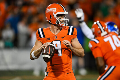 The Quarter back for the Fighting Illini during about to throw the ball on the football field