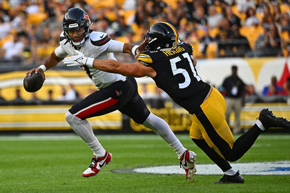 C.J. Stroud of the Houston Texans stiff arms Nick Herbig of the Pittsburgh Steelers