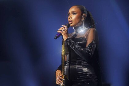 Jennifer Hudson sings onstage in a black gown.