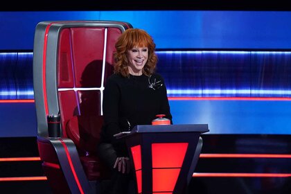 Reba McEntire sits in a judge's chair on The Voice Season 26 Episode 10.