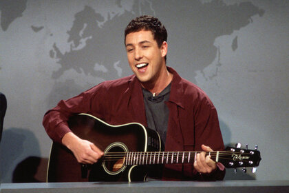 Adam Sandler performs with a guitar during Weekend Update on Saturday Night Live.