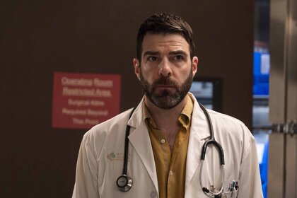 Dr. Oliver Wolf (Zachary Quinto) wears a doctor's coat in Brilliant Minds Episode 107.