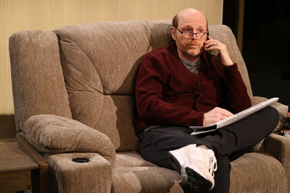 Bill Burr sits on a couch during a sketch on Saturday Night Live Season 50 Episode 6