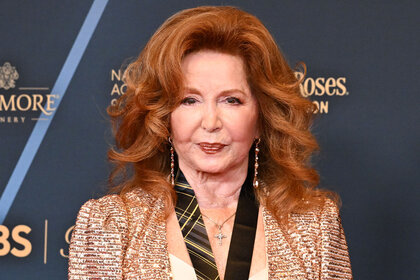 Suzanne Rogers posing in front of a step and repeat.