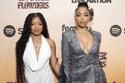 Halle Bailey and Chloe Bailey pose together in white and silver dresses.