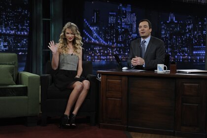 Taylor Swift waves next to Jimmy Fallon on Late Night with Jimmy Fallon Episode 140.