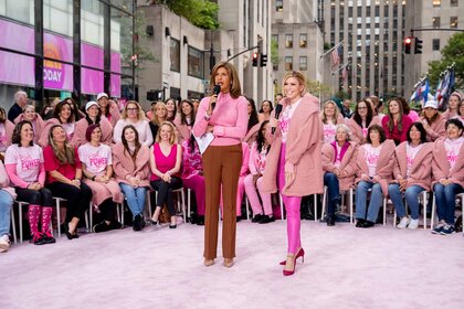 Hoda Kotb and Jill Martin speak in front of a crowd of women dressed in pink.