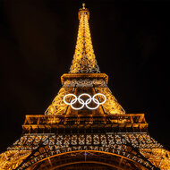 The Olympic rings on the lit up Eiffel Tower at nigh