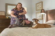 Kate packing a bag while Audio the dog lays next to her on the bed