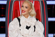 Gwen Stefani smiles while sitting in her chair on The Voice