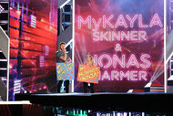 Jonas Harmer and Mykayla Skinner hold up signs during the American Ninja Warrior Season 14 Couples Special.