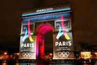 The Paris Olympics 2024 logos are projected onto the Arc de Triomphe.