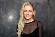 Kelsea Ballerini smiles in a black sheer top at a fashion show