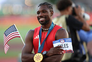 Noah Lyles poses with his medal and flag after winning the men's 100 meter final