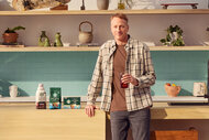 Tony Hawk stands next to starbucks coffee productcs in a kitchen for a collab with starbucks
